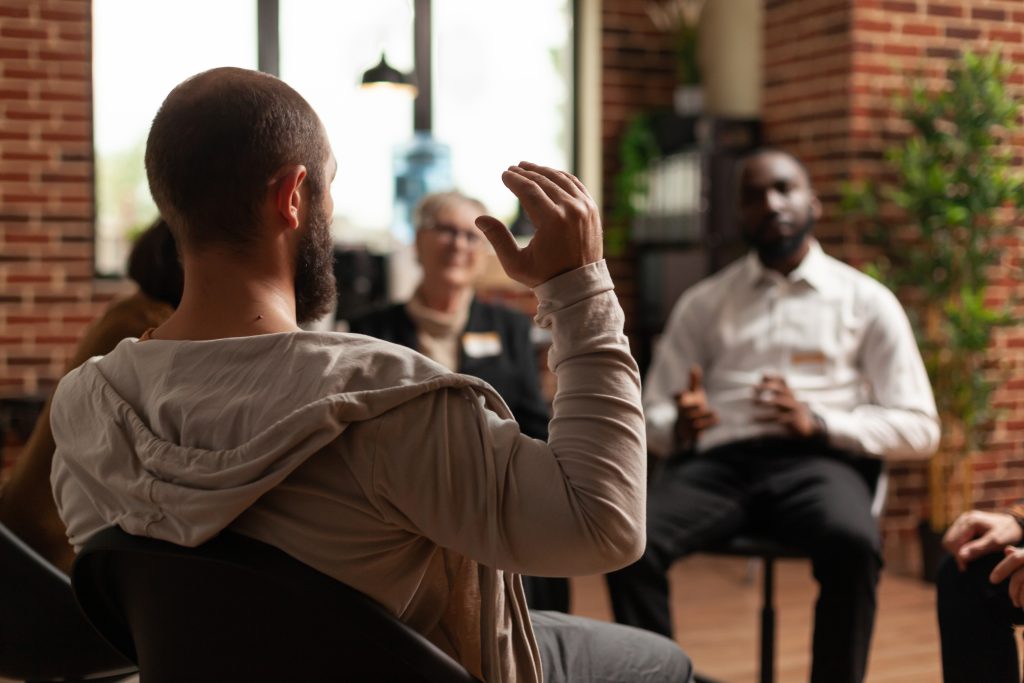 Man sharing mental health issues with a group.