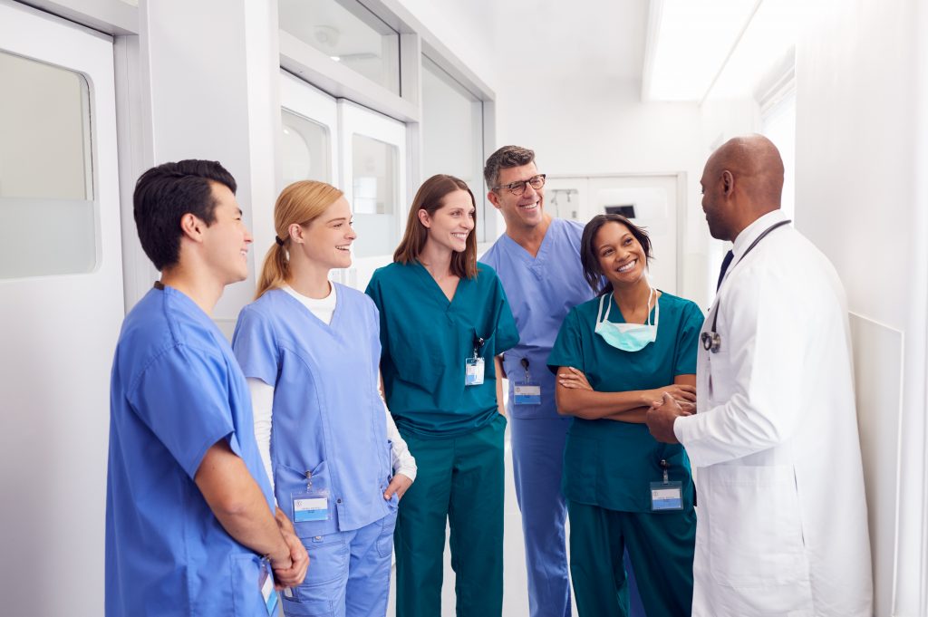 Diverse medical team discussing in a hospital corridor.