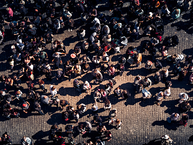 Aerial view of a large crowd of people gathered in a square, seen from directly above.