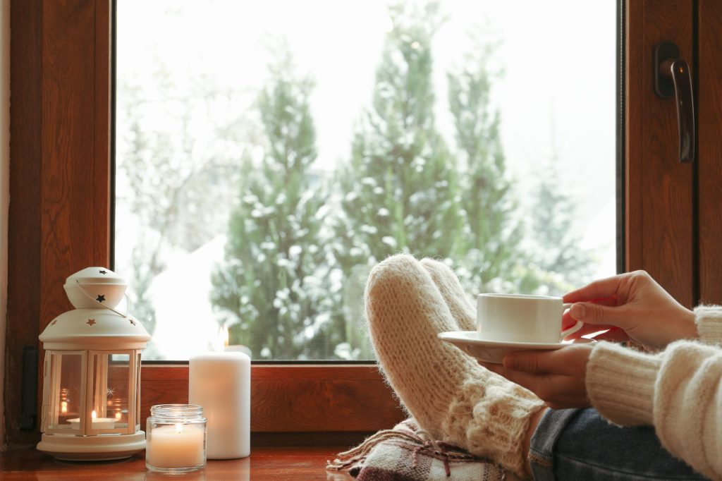 Relaxing cozy inside with a hot drink looking out at a winter day.