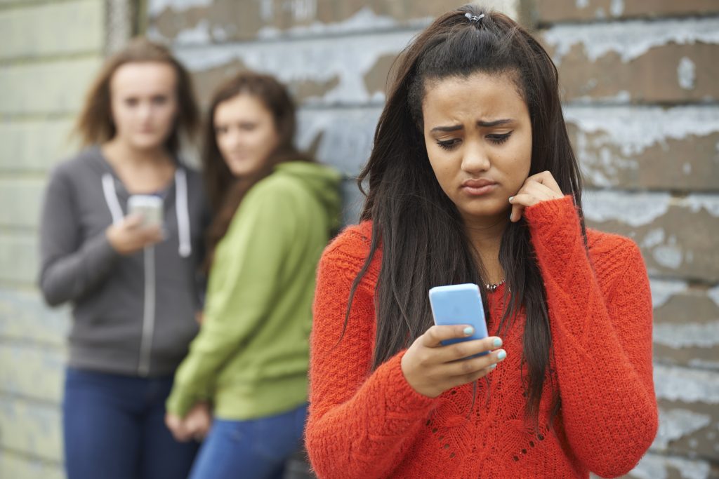 Teenage girl being bullied by text message.