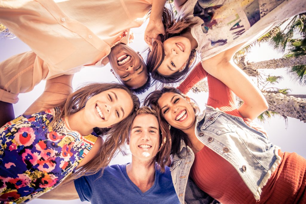 Group of friends with their heads in a circle pressed together having fun.