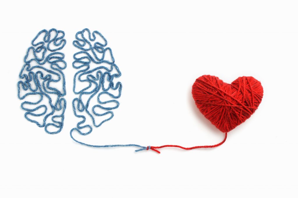 An illustration of a blue brain connected to a red heart with a string.