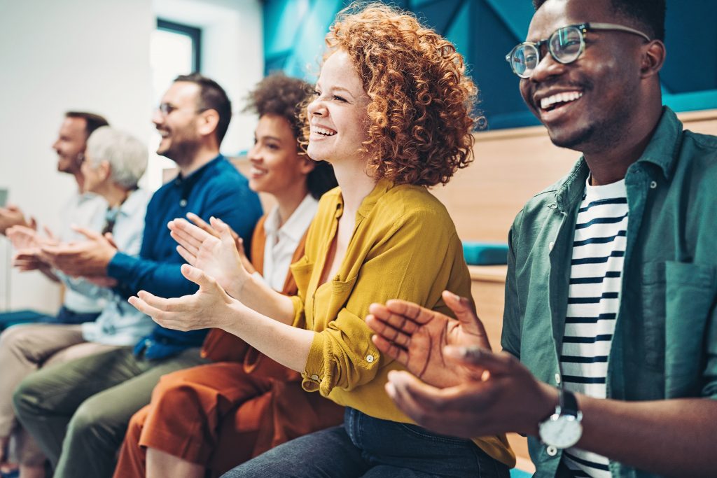 Group of people sitting in a row and applauding